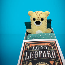 Load image into Gallery viewer, Mini beige leopard felt toy that comes in its own bespoke matchbox. Complete with pillow and bedding - perfect for tucking in at night time. Your little friend also comes with an adoption certificate, collectible playing card, and thank you card.