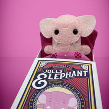 Load image into Gallery viewer, Handmade from felt this mini pink elephant toy stands 110mm high and is perfect for your kids to that with them on their travels and adventures. Your little friend is small enough to fit in a pocket and comes with its own matchbox and bedding. 