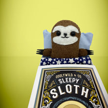 Load image into Gallery viewer, Handmade from felt this mini brown sloth toy stands 110mm high and is perfect for your kids to that with them on their travels and adventures. Your little friend is small enough to fit in a pocket and comes with its own matchbox and bedding. 