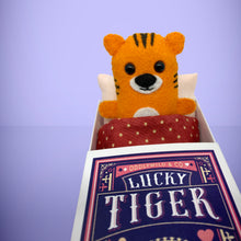 Load image into Gallery viewer, Handmade from felt this mini orange tiger toy stands 110mm high and is perfect for your kids to that with them on their travels and adventures. Your little friend is small enough to fit in a pocket and comes with its own matchbox and bedding. 